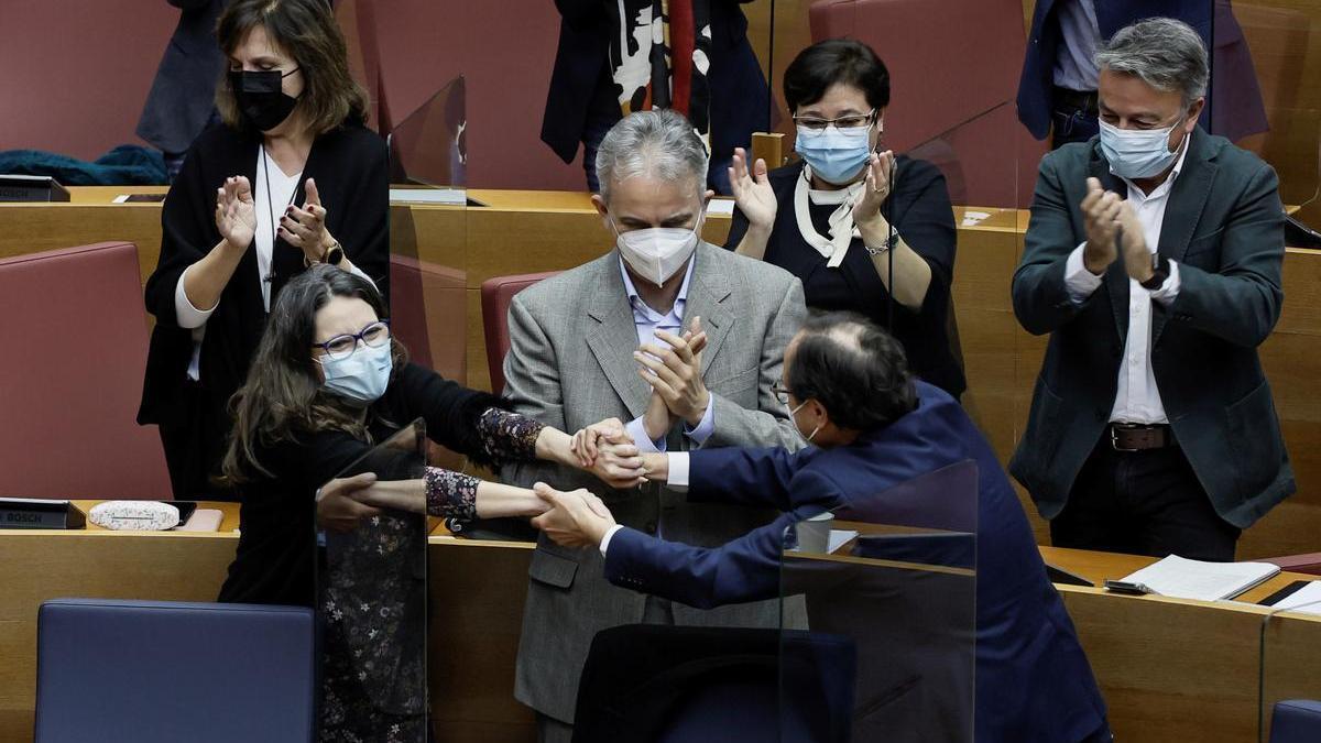 La vicepresidenta del Consell, Mónica Oltra, abraza al conseller de Hacienda, Vicent Soler, durante el pleno.