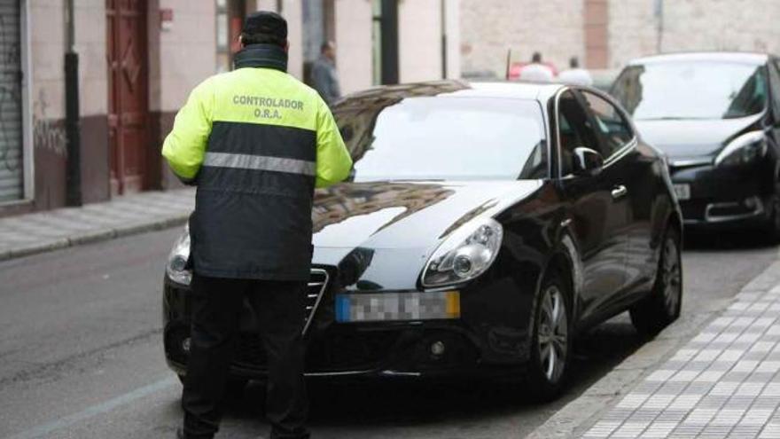 Un controlador supervisa un vehículo aparcado en zona azul en el entorno del Mercado.