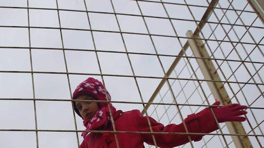 Una niña, tras la verja del paso fronterizo turco-sirio de Oncupinar.