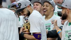 Tatum abraza su trofeo de MVP, que recibió tras el triunfo en Miami, mientas es felicitado por sus compañeros