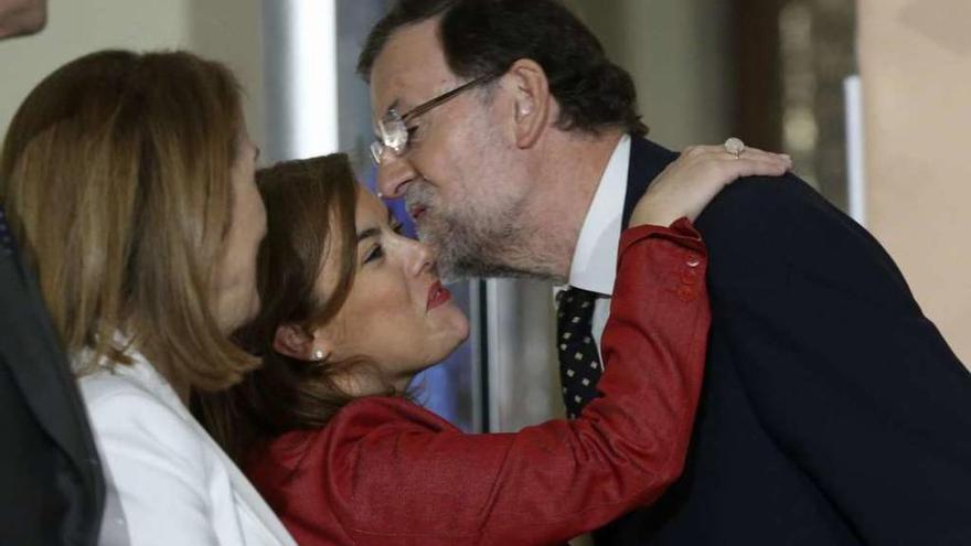Rajoy saluda a la vicepresidenta Soraya Sáenz de Santamaría, en presencia de la ministra Ana Pastor. // Efe