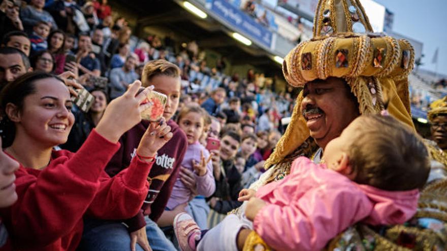 El Rey Baltasar acuna a una niña en el estadio.