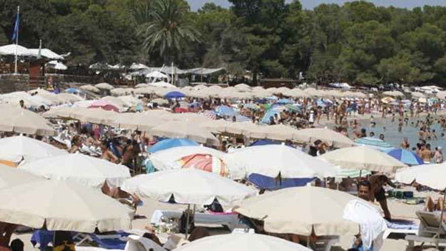 Turistas en las hamacas de la playa de Cala Bassa.