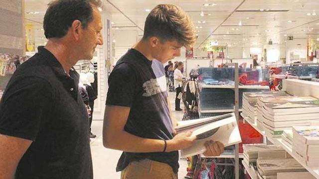 Un estudiante de bachiller y su padre buscan libros de texto en El Corte Inglés.