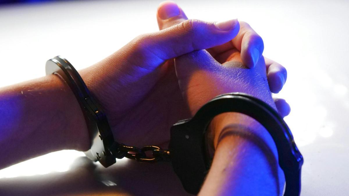 Manos con unas esposas en una detención.