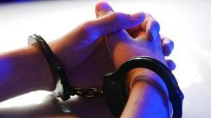 Manos con unas esposas en una detención.