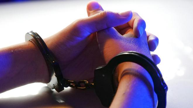 Manos con unas esposas en una detención.