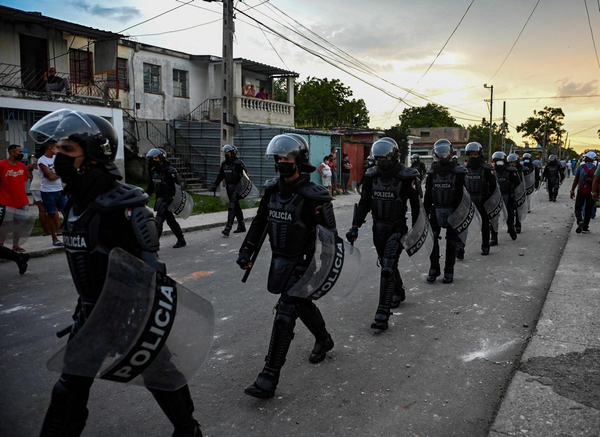 Policías antidisturbios patrullan por las calles de Arroyo Naranjo tras las manifestaciones contra el Gobierno de Miguel Díaz-Canel.