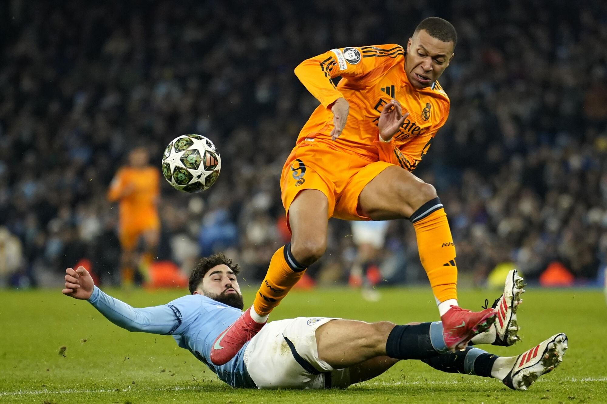 Manchester City's Josko Gvardiol, left, challenges Real Madrid's Kylian Mbappe during the Champions League playoff first leg soccer match between Manchester City and Real Madrid at the Etihad Stadium in Manchester, England, Tuesday, Feb. 11, 2025. (AP Photo/Dave Thompson)