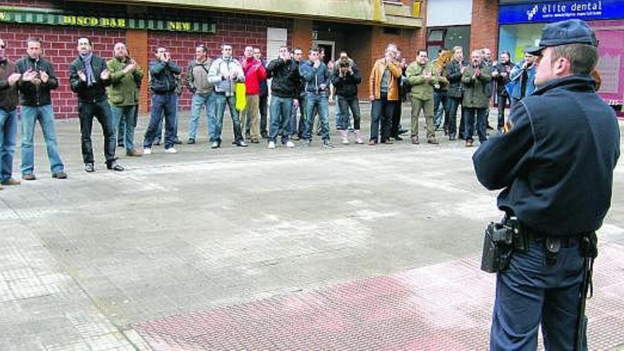 En la imagen superior, Francisco Javier Velázquez saluda a Miguel Ángel Marcos, en presencia de Antonio Trevín. Sobre estas líneas, policías locales durante la protesta ante la sede, con un agente antidisturbios en primer término.