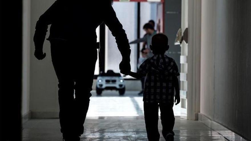 Un niño camina agarrado de la mano en un hospital.