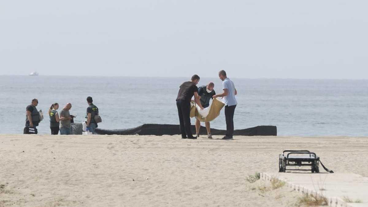 Els equips d'emergències, junt amb el cadàver trobat a la platja de Roda de Berà.