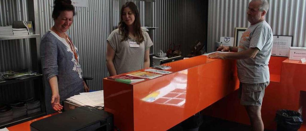 María José Fernández y Eva Gutiérrez, atendiendo a Fernando Muñoz en la oficina de turismo.