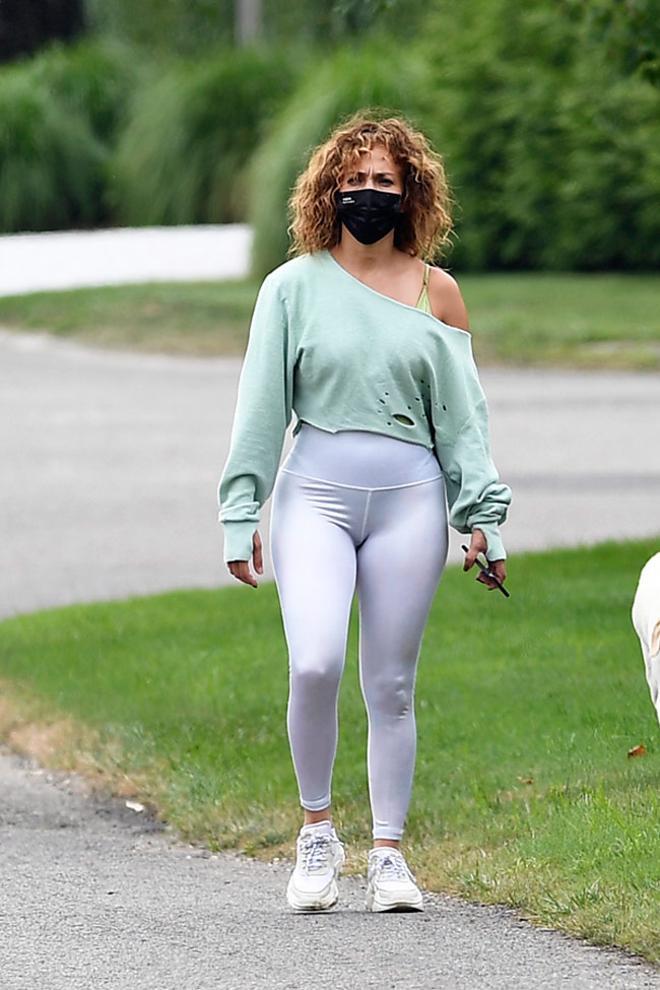 Jennifer Lopez con look deportivo: jersey de cuello abierto, leggings de Alo Yoga y zapatillas deportivas