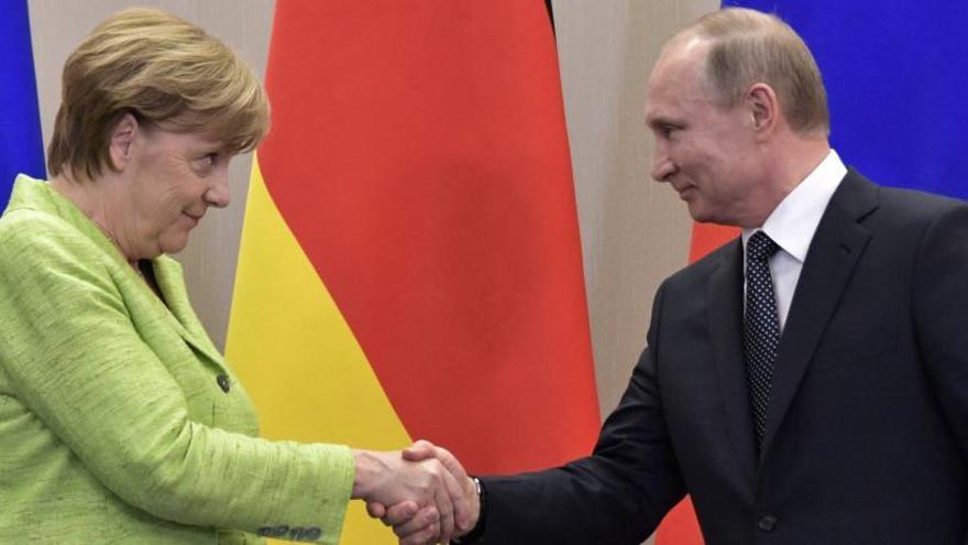 Angela Merkel y Vladimir Putin se dan la mano este martes.