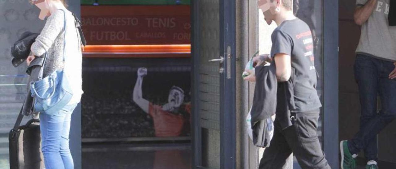 Jóvenes en la puerta de un local de apuestas deportivas en Santiago. // Xoán Álvarez