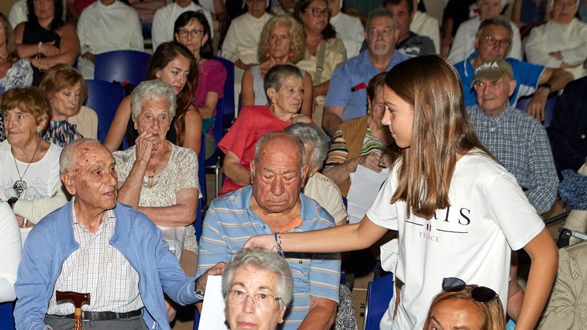 Una niña de Belchite entrega uno de los recuerdos a un superviviente de la guerra civil, ayer.