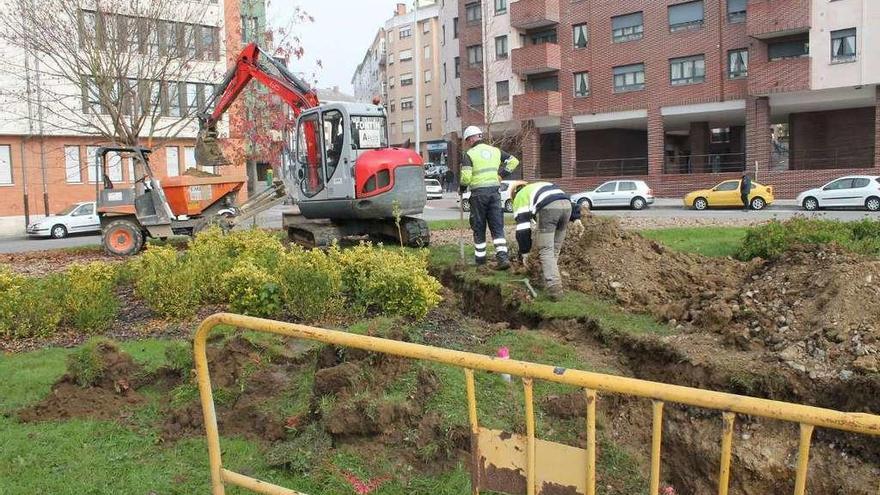 Operarios trabajando ayer en la glorieta de la plaza de la Paz de la Pola.