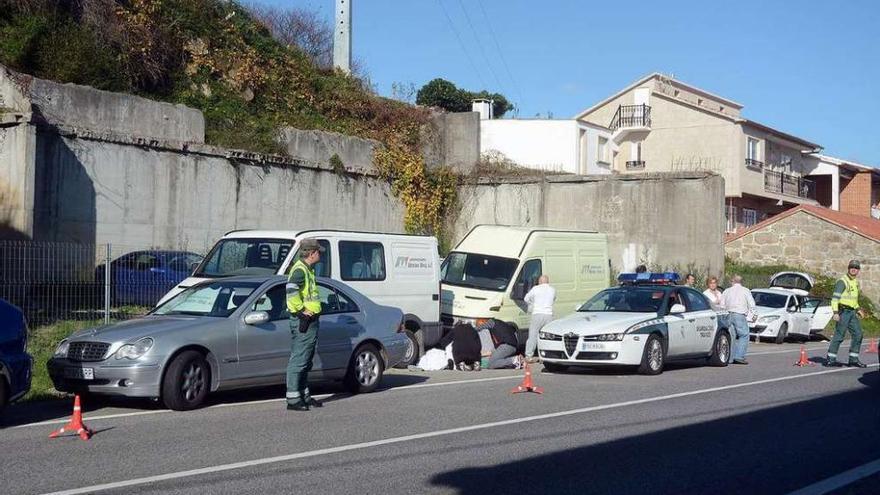 La víctima, cubierta con una sábana al lado del Mercedes, y al fondo el coche que limpiaba. // R.V.