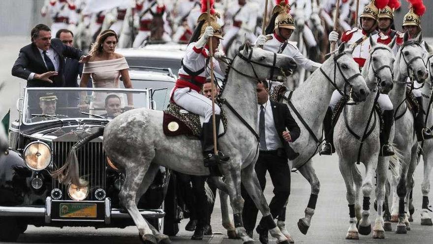 Bolsonaro y su esposa, Michele, reaccionan al percance de uno de los caballos de la comitiva en su camino al palacio de Planalto. // Efe