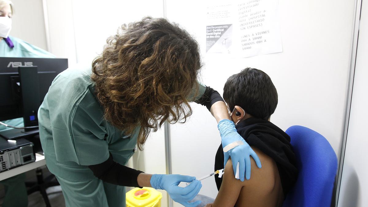 Una sanitaria vacuna a un niño contra el coronavirus.