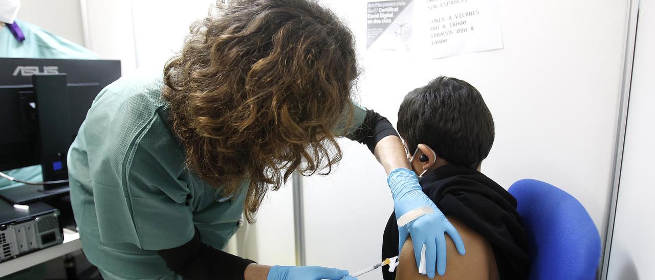 Una sanitaria vacuna a un niño contra el coronavirus.