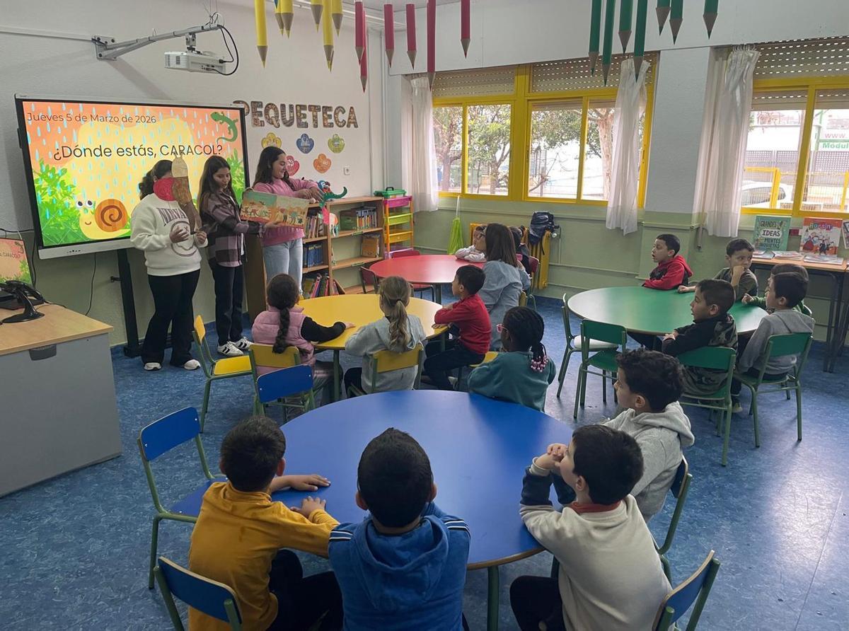 A la izquierda, una presentación durante la visita; a la derecha, docentes del centro de ambos centros a las puertas del CEIP Antonio Monzón. | L.O.