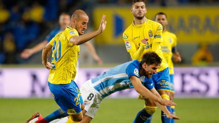 Gálvez, de Las Palmas, derriba al jugador del Málaga Adrián.