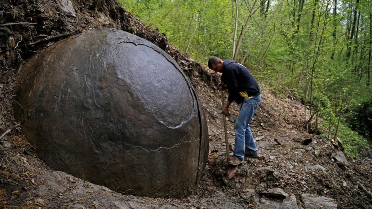 Suad Keserovic limpia la esfera de piedra en Podubravije, cerca de Zavidovici (Bosnia), el 11 de abril.