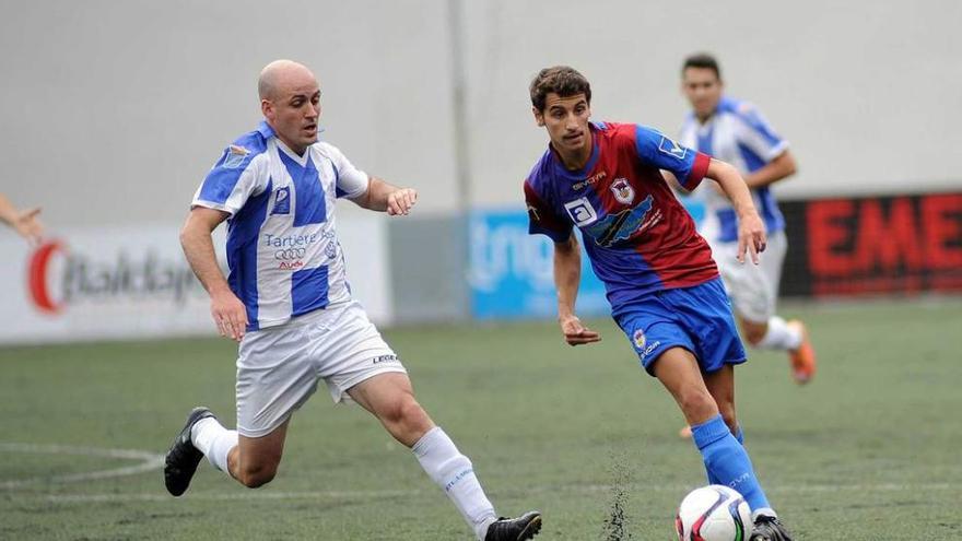 Luis Nuño conduce el esférico ante Miguel en un Langreo-Lugones.