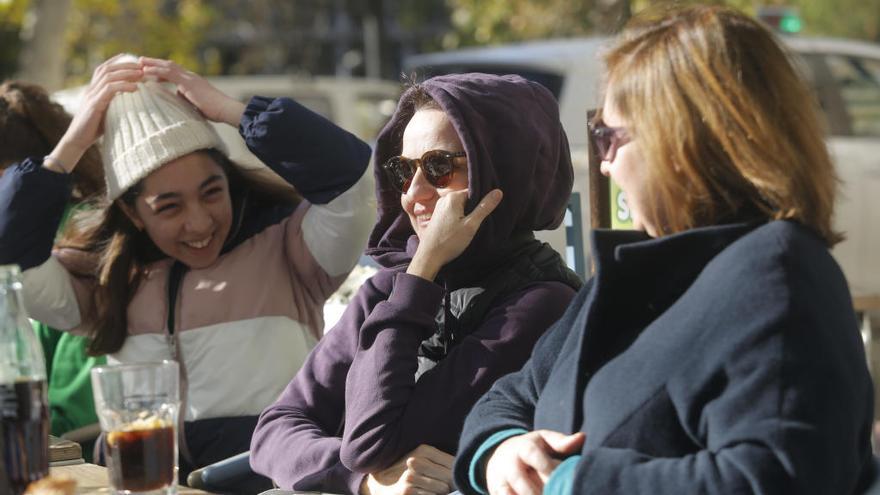 Tres mujeres disfrutan del domingo soleado en València.