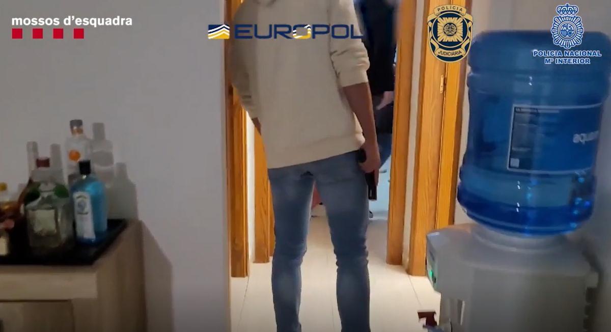 Un policía armado con su pistola durante un registro de la operación.