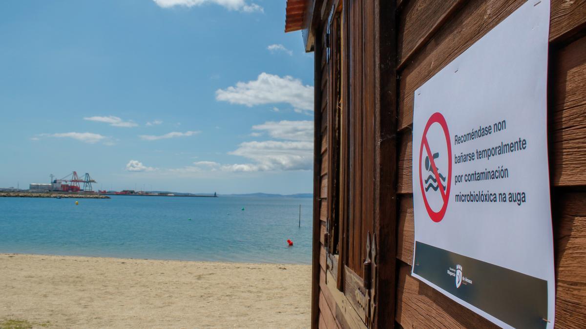 Uno de los carteles colocados ayer en la playa Compostela que recomienda no bañarse.