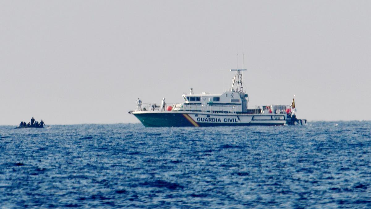 Ein Boot mit Migranten und ein Schiff der Guardia Civil vor der Küste von Andalusien (Archivbild von 2020)