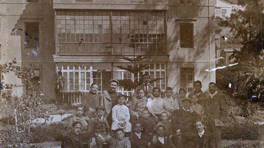 Grupo de alumnos y profesores en la parte posterior del edificio principal de la academia, a comienzos del siglo XX.