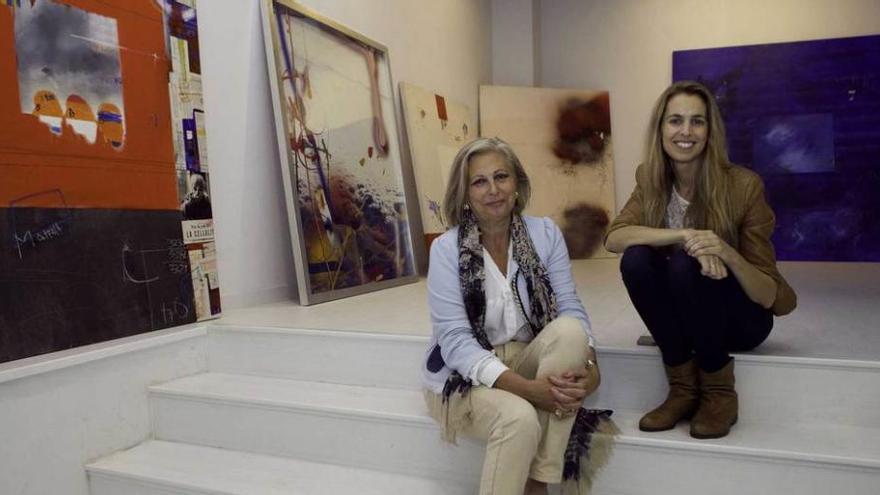 Las galeristas Gema Llamazares, a la izquierda, y Diana González, con algunas de las obras para la muestra &quot;Kely, una vida pintada&quot;.