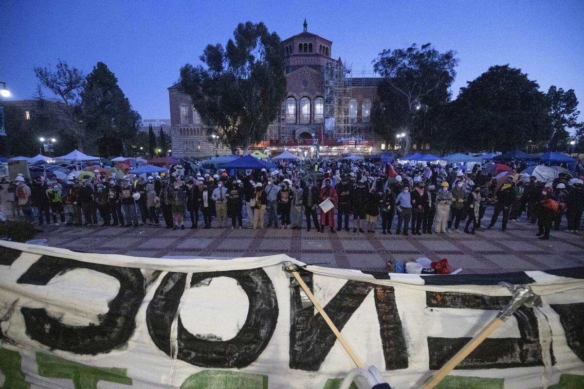 Pro-Palestinian demonstrators lock arms on the UCLA campus Wednesday, May 1, 2024, in Los Angeles. (AP Photo/Ethan Swope)