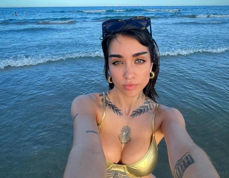 María Becerra posando en una playa