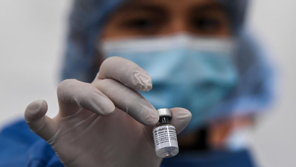 Un sanitari sosté un vial de la vacuna de Pfizer.