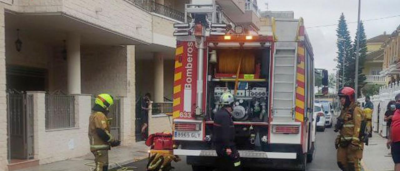 Los bomberos sofocando el incendio en el garaje de la vivienda