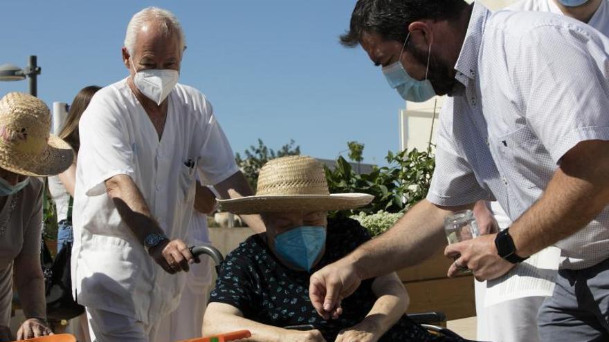 Santiago Marí ayuda a una usuaria a sembrar judías. | VICENT MARÍ
