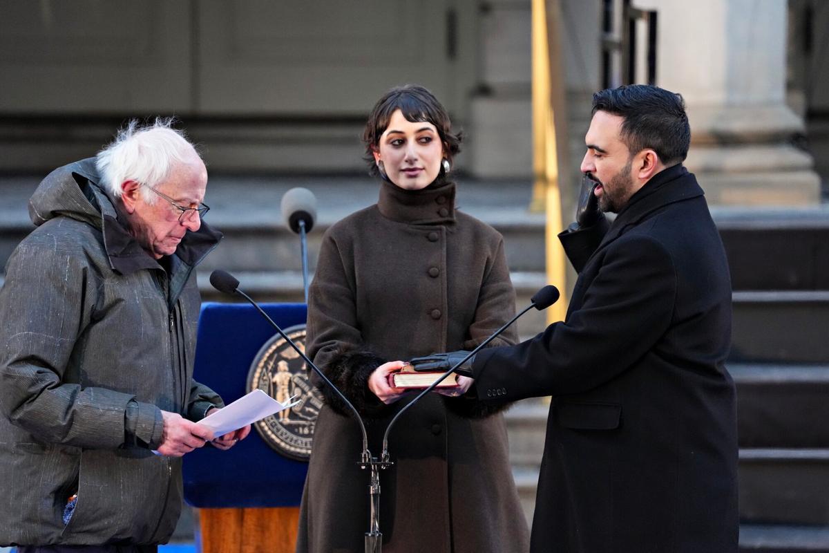 Senator Bernie Sanders, an Independent from Vermont, left, administers the oath of office to Zohran Mamdani, mayor of New York, right, during an inauguration ceremony with Rama Duwaji, center, at City Hall in New York, US, on Thursday, Jan. 1, 2026. A 34-year-old democratic socialist born in Uganda, Mamdani becomes the city's first mayor of South Asian descent, its first Muslim mayor and the youngest leader of the metropolis of nearly 8.5 million people in more than a century. Photographer: Adam Gray/Bloomberg