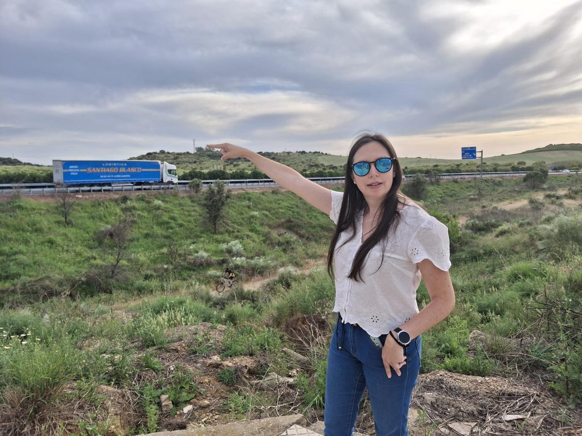 Pilar Brinquete señala la autovía en el momento en el que pasa un camión junto a las viviendas más cercanas.