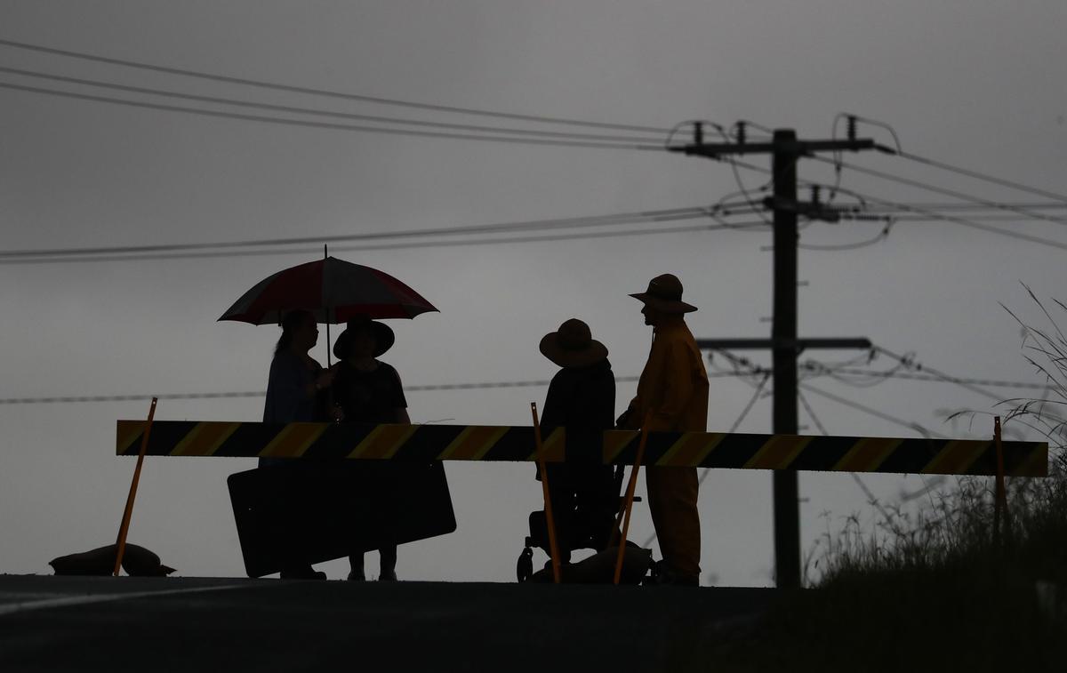 Residentes locales cerca de una carretera cortada por las inundaciones cerca de Kempsey (Australia)