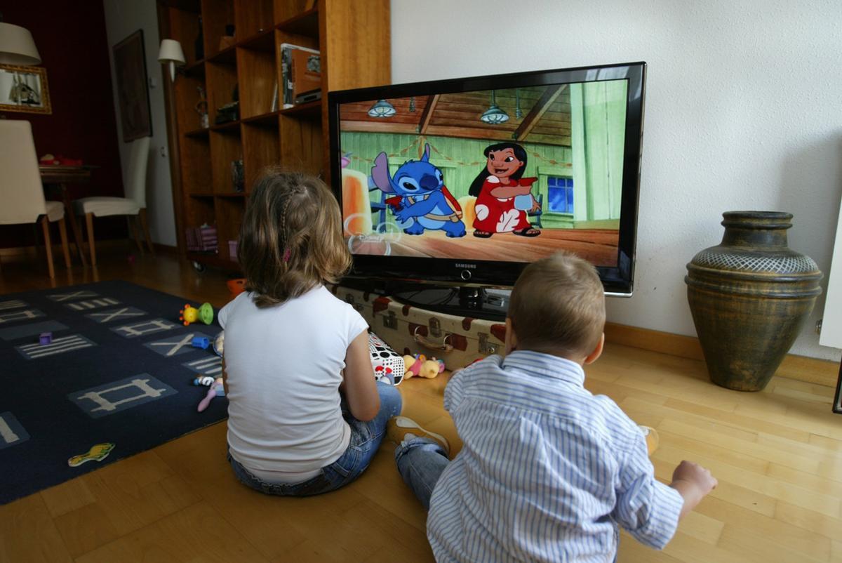 Unos niños miran la tele. 