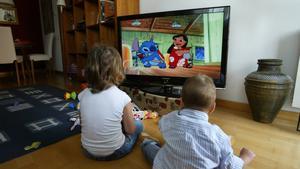 Unos niños miran la tele. 