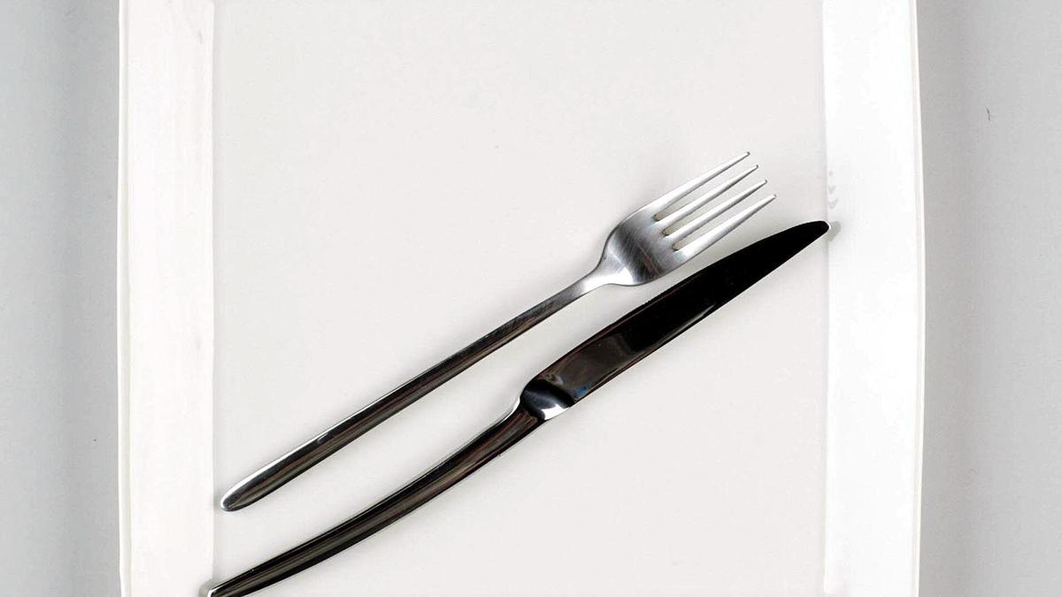 Un plato con cubiertos encima.