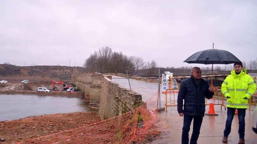 El subdelegado de Gobierno (con el paraguas) en el acceso al puente que sigue cortado al tráfico.