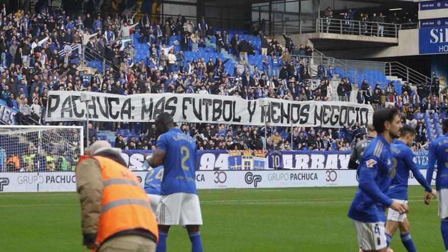 Arriba, el tifo desplegado  en el Fondo Norte. Abajo, Martín Peláez abandona el Tartiere en su coche, con varios aficionados gritando a su paso. | MIKI LÓPEZ