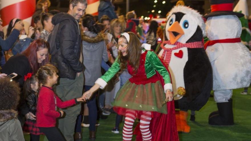 Un elfo saluda a una niña en el desfile de la llegada de la Navidad del año pasado.